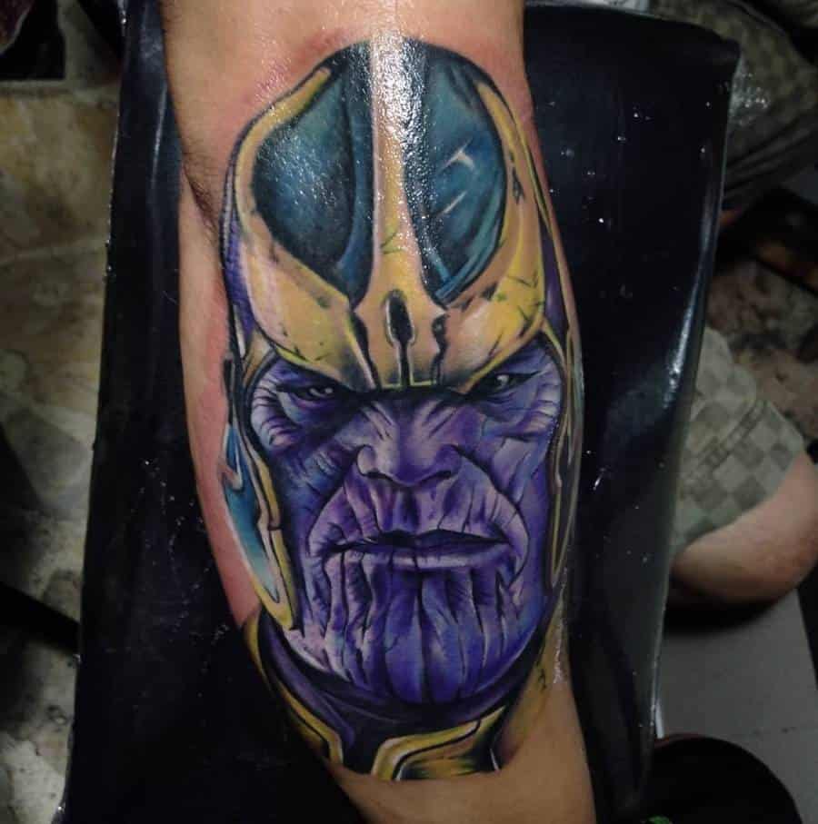 A vibrant tattoo of Thanos, showcasing his face with detailed purple and yellow shading on his helmet and skin