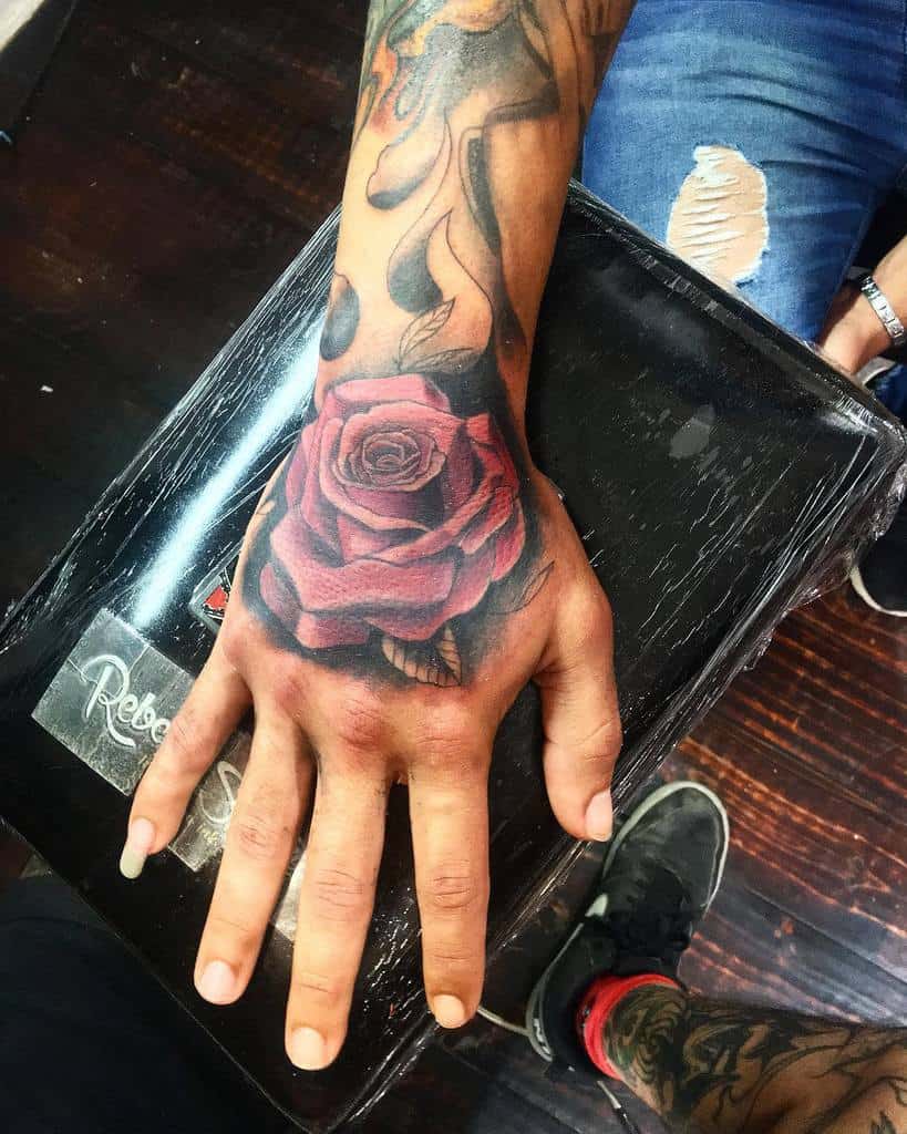 A hand adorned with an intricate rose tattoo