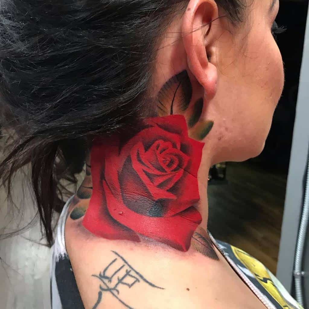 Close-up of a vibrant red rose tattoo elegantly inked on the person's neck