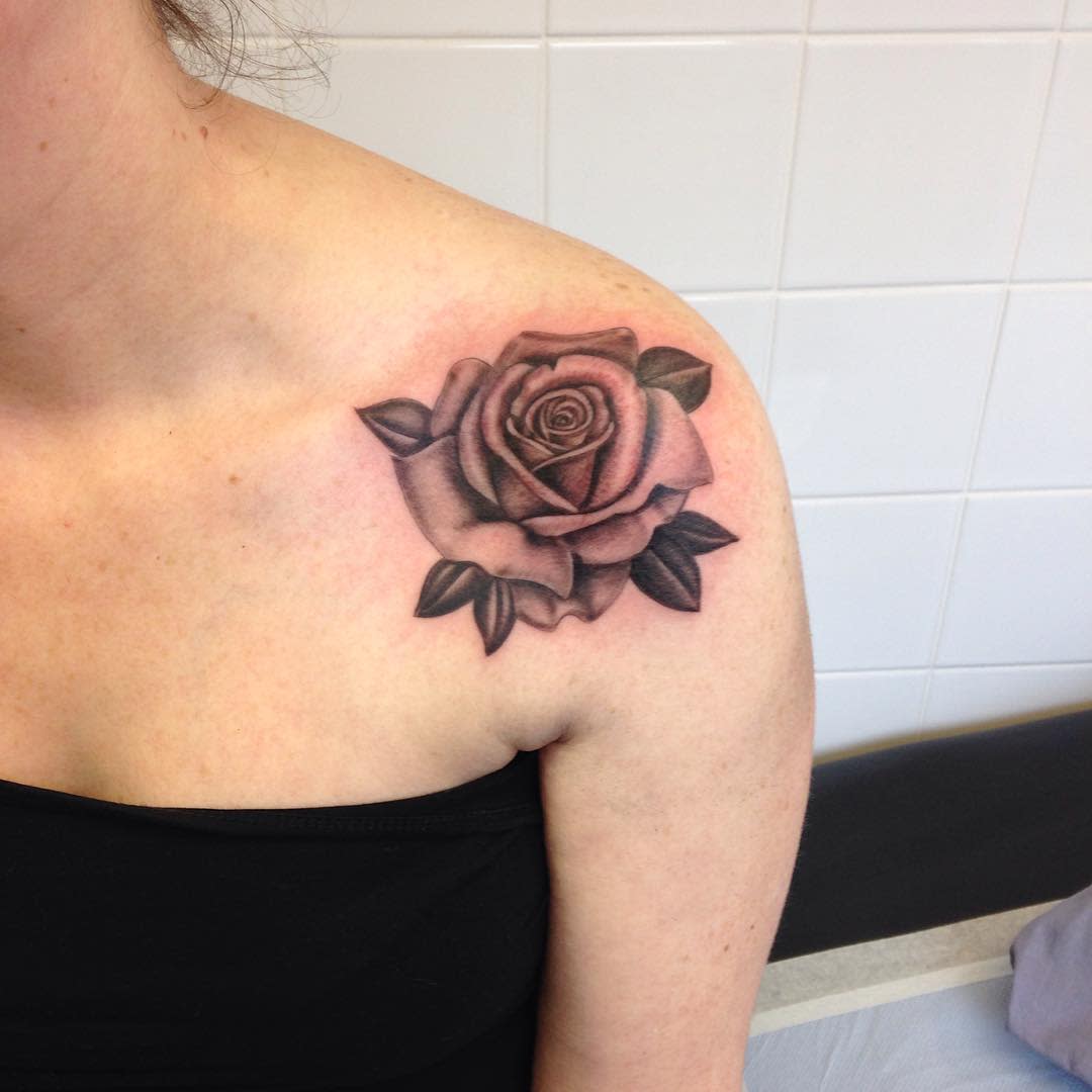 Black and gray rose tattoo on a person's right shoulder
