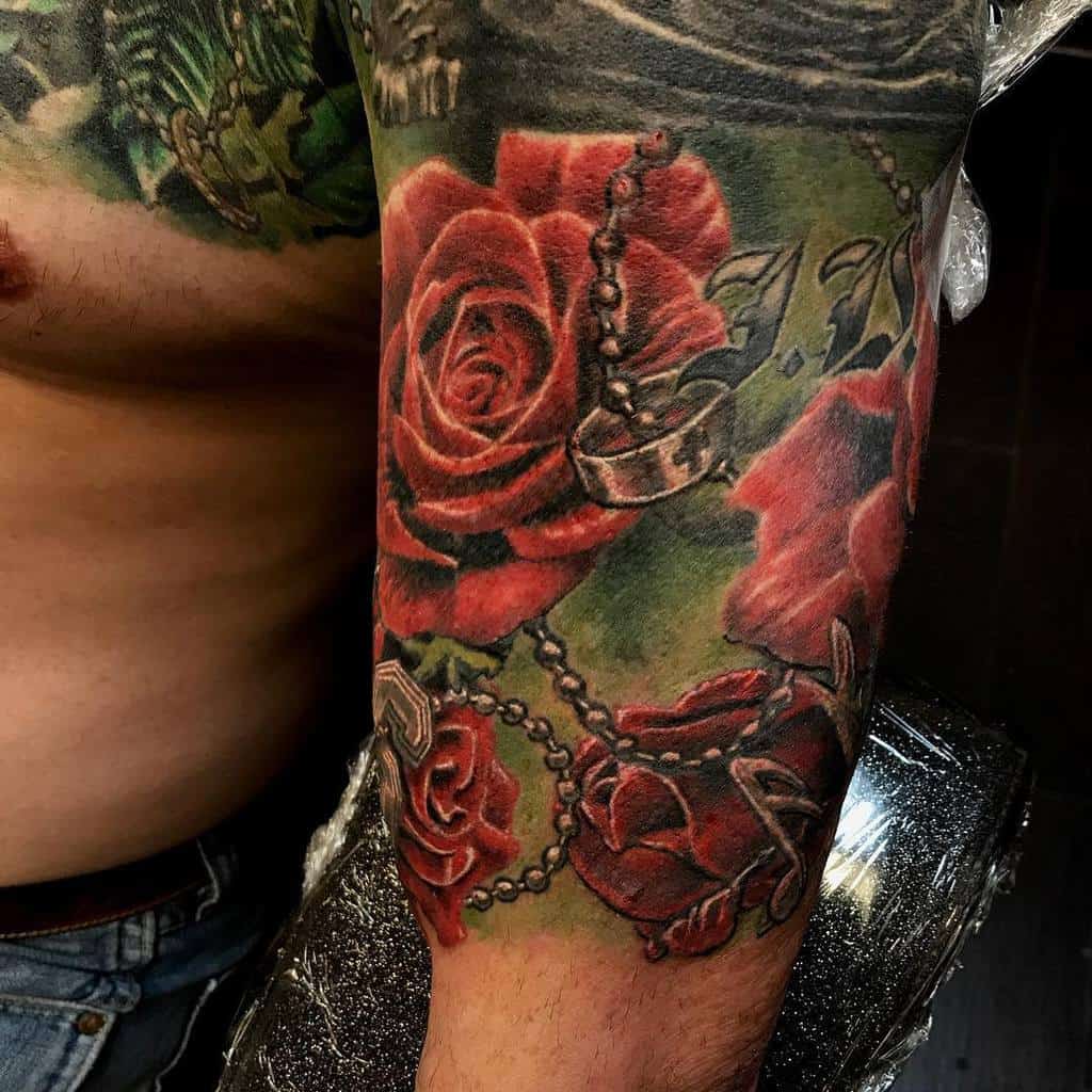 Close-up of a tattooed sleeve adorned with red roses and interwoven chains