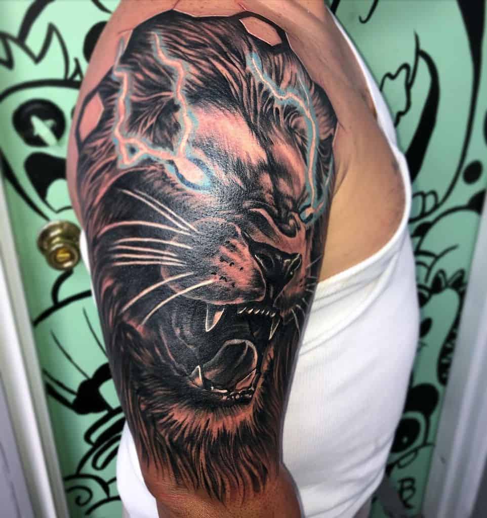 Tattoo of a roaring lion with lightning on a man's upper arm