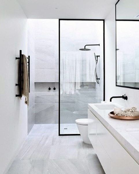 Minimalist bathroom with a sleek glass shower, white counter, dual sinks, and modern black fixtures