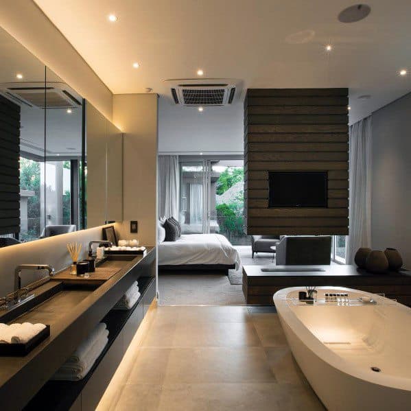 Open-concept bathroom with freestanding tub, LED-lit mirror, and modern recessed lighting.