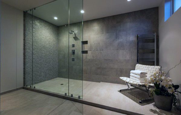 Modern master bathroom shower with glass enclosures, recessed mini ceiling lights, and a stylish stone accent wall for a sleek, minimalist design