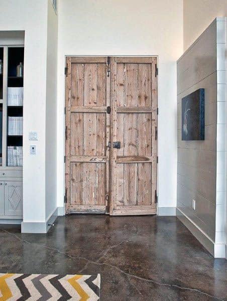 A rustic reclaimed wood closet door with a vintage design, adding a charming and natural touch to the room’s decor