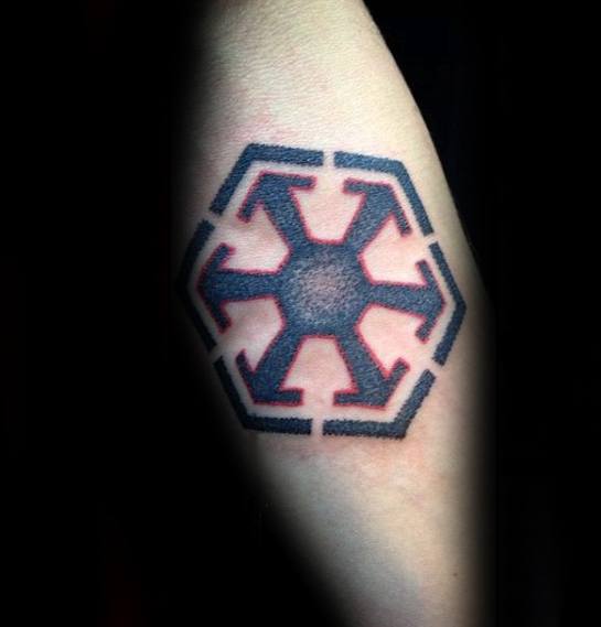Sith Empire symbol tattoo in black ink with red shadowing, placed on the forearm and designed with clean lines and subtle gradient shading.