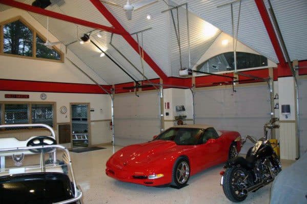 Garage with vaulted red and white ceiling, bright lighting, and sports vehicles.