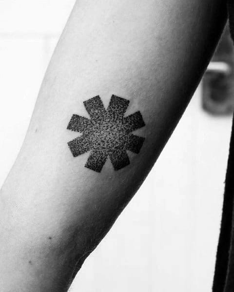 Minimalist forearm tattoo featuring the Red Hot Chili Peppers logo with a detailed dotwork shading effect for a subtle yet bold design.