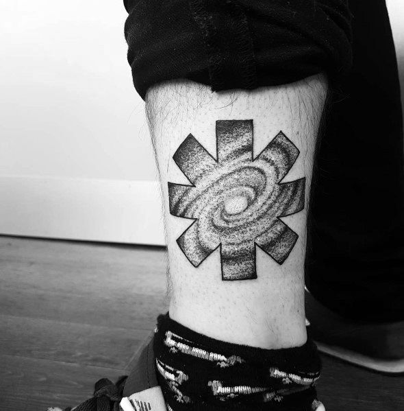 Ankle tattoo featuring the Red Hot Chili Peppers logo with a detailed galaxy swirl inside, creating a cosmic and artistic design.