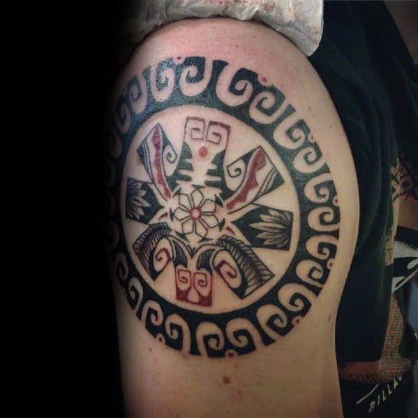 Upper arm tattoo featuring a tribal-inspired design incorporating the Red Hot Chili Peppers logo, surrounded by intricate geometric patterns.
