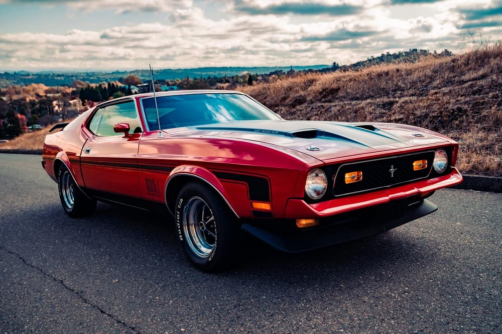 red mustang mach 1 cruises down the road