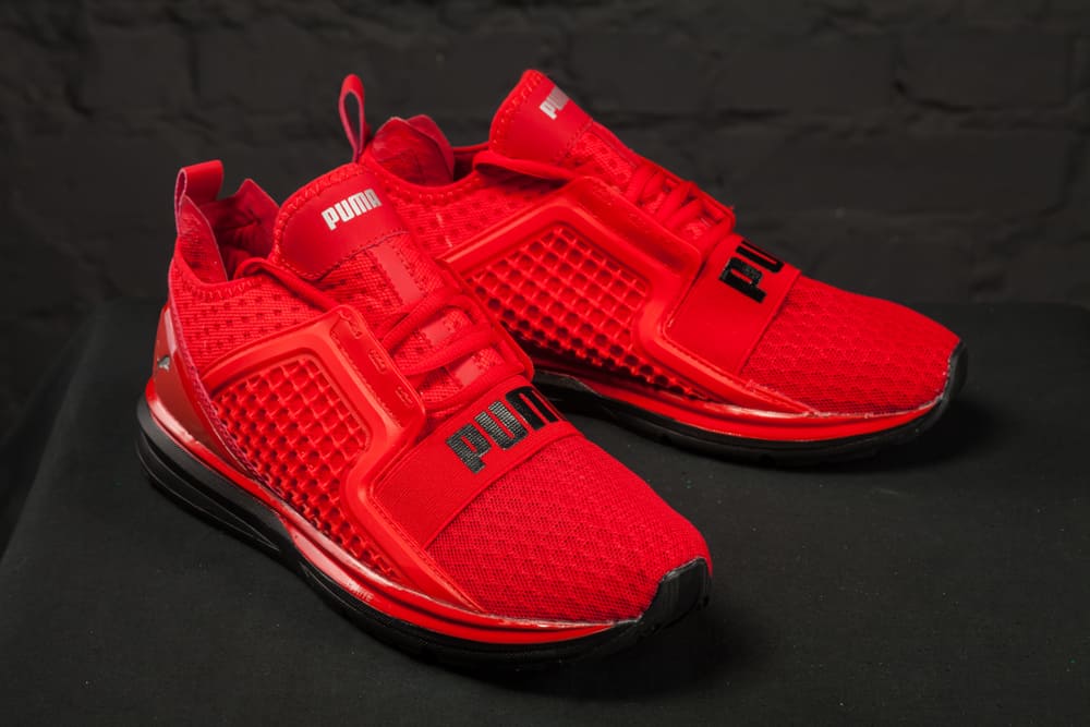 red puma shoes on black surface