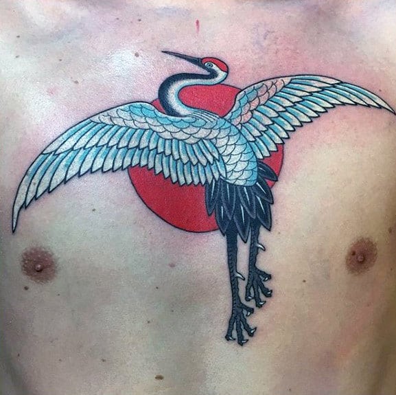 Tattoo of a crane with outstretched wings over a red sun on a chest