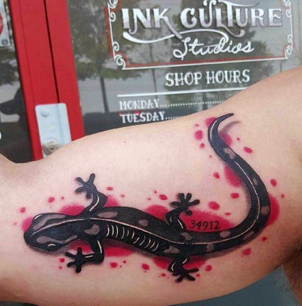 Bold black gecko tattoo with subtle pink accents, set against a splash of red dots and the number 34912 on the side.