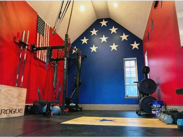 Patriotic garage gym with Rogue rack, platform, weights, and star-themed decor.