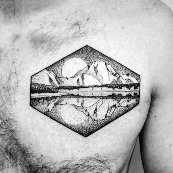 Tattoo of a geometric mountain landscape with a sun and its reflection in a lake, created with fine dotwork for a minimalist and artistic look.