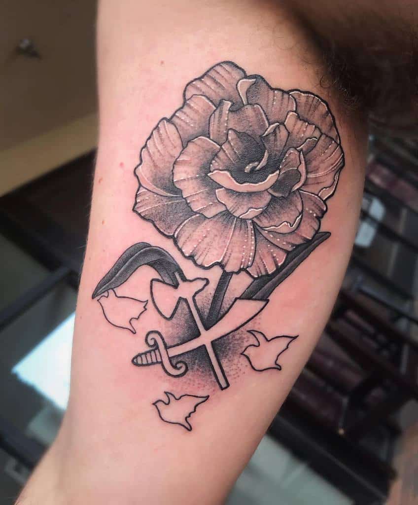 Tattoo of a detailed carnation flower with leaves and flying birds silhouette with ax and sword