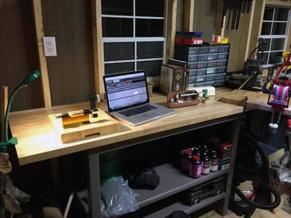 Workbench with a laptop, tools, and storage containers in a workshop