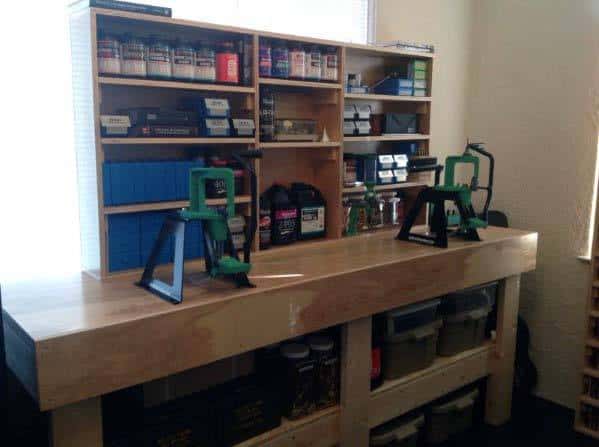 Clean and organized reloading bench featuring mounted presses, ample storage shelves for supplies, and neatly arranged bins for tools and components