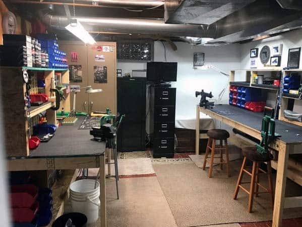 Well-designed reloading room with multiple workbenches, mounted presses, organized storage shelves, and ample lighting for a functional and efficient workspace
