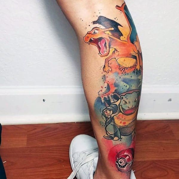 Colorful watercolor-style leg tattoo featuring Charizard, Blastoise, and a Poké Ball, blending vivid hues with a dreamy artistic flair.