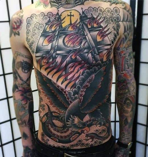 Full back tattoo featuring a large burning church with flames and smoke under a yellow sun. A fierce black eagle with spread wings dominates the lower half.