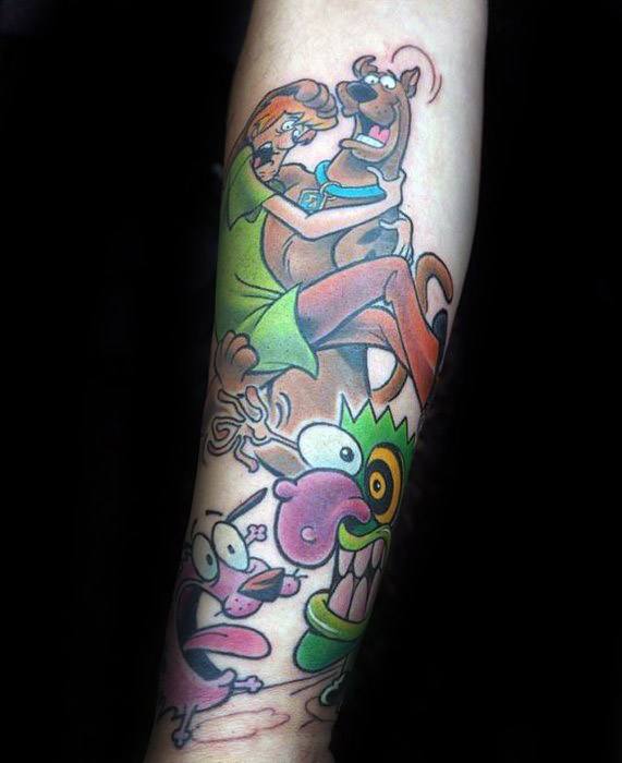 Colorful forearm tattoo of Shaggy and Scooby-Doo leaping in fear above a group of zany cartoon monsters, capturing classic spooky cartoon chaos.