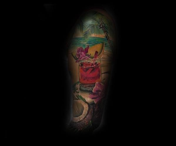 Realistic tropical beach tattoo featuring a red cocktail, coconut, orchid flowers, and ocean view with palm trees, placed on the upper arm.