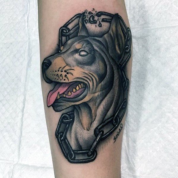 Stylized Doberman tattoo with bold outlines, expressive eyes, and a broken chain around the neck, symbolizing strength and freedom.