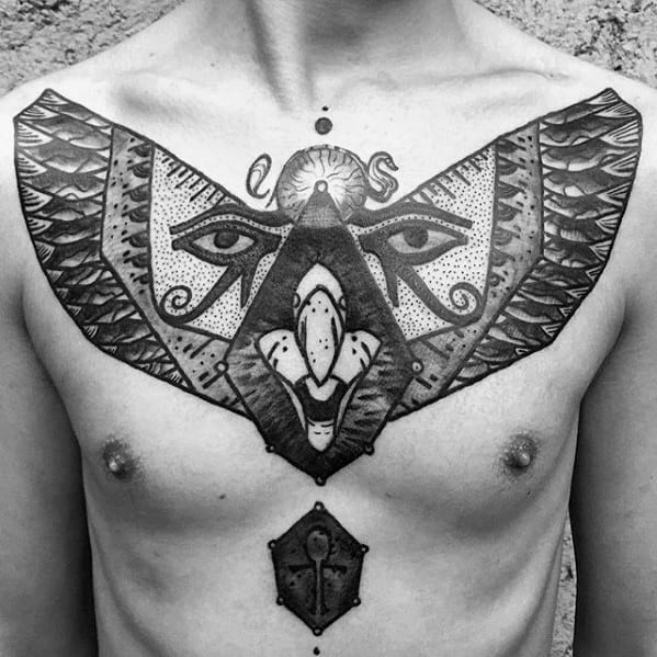 Tattoo of a symmetrical falcon or hawk with wide wings, embedded eyes, and esoteric symbols, spreading across the chest with bold lines.