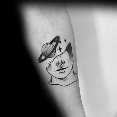 Abstract Saturn tattoo design for men featuring a faceless figure with a planet and stars emerging from the head in black linework.