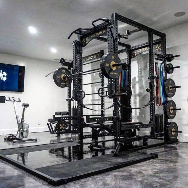 Modern garage gym with power rack, weight plates, resistance bands, and epoxy-coated floors.