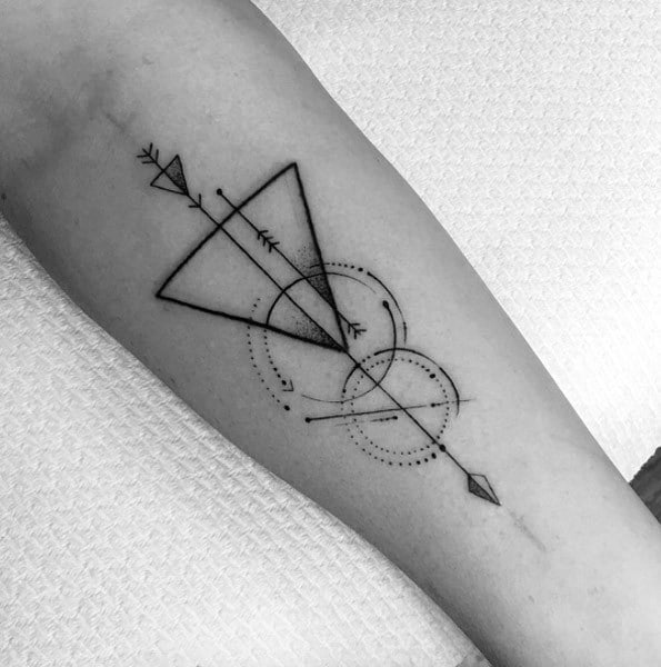 Minimal geometric arrow tattoo with overlapping triangles, dotted circles, and fine linework for a clean, abstract forearm design.