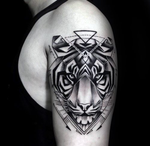 Bold geometric tiger tattoo on the upper arm, combining sharp black shapes, gradient shading, and piercing eyes for a powerful design.