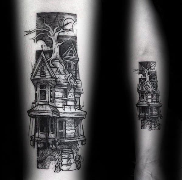 Forearm tattoo of a haunted Victorian house with a twisted tree growing through it, detailed linework, and eerie architectural features.