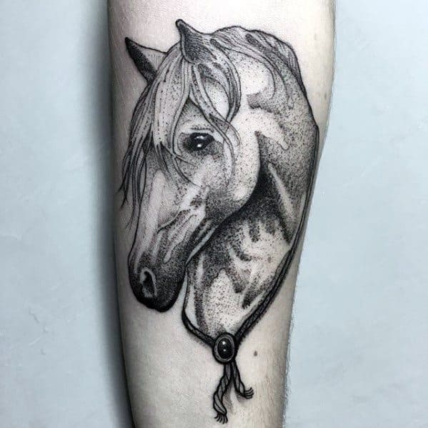 Dotwork-style tattoo of a horse head with gentle expression and flowing mane, placed on the forearm with a rope-like frame detail