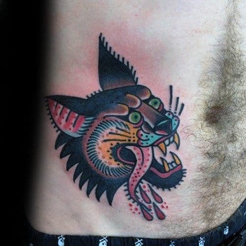 Traditional-style hyena head tattoo on the torso with bold black outlines, vibrant colors, and exaggerated tongue and fang details.