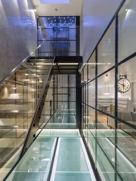 Futuristic glass staircase with glass walkway and glass railing in a modern luxury interior.