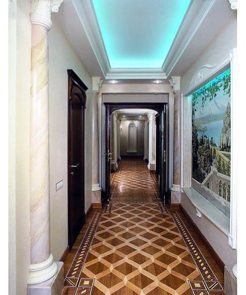 
Stylish hallway with modern crown molding lighting and artistic touches, featuring a unique geometric floor design and soft ambient lighting