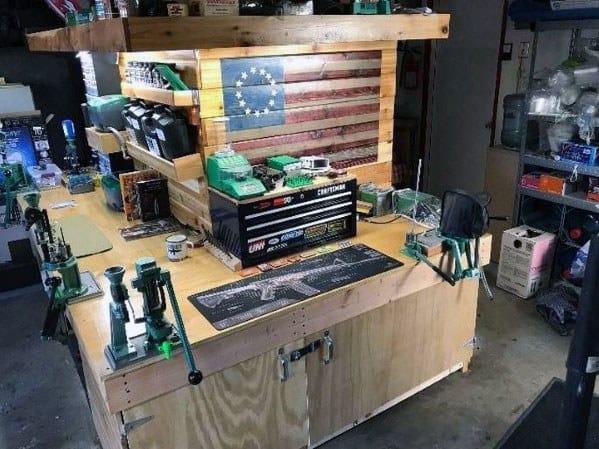 Impressive reloading bench setup featuring a sturdy wooden design, organized storage for tools and components, and a striking American flag backdrop for a personalized workspace