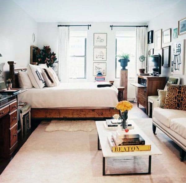 Cozy studio apartment with warm wooden furniture, a stylish coffee table, and natural light.