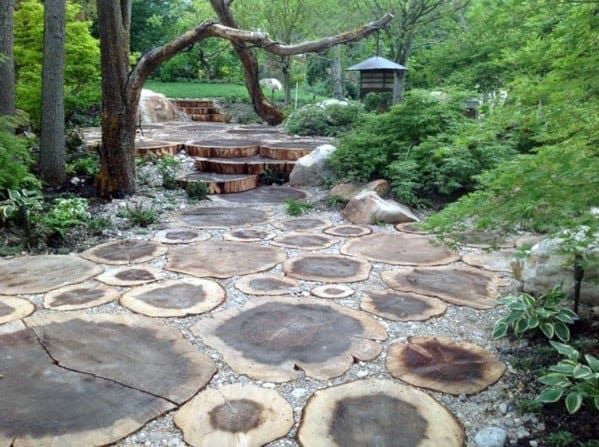 Walkway with large, circular wooden steps surrounded by greenery and trees
