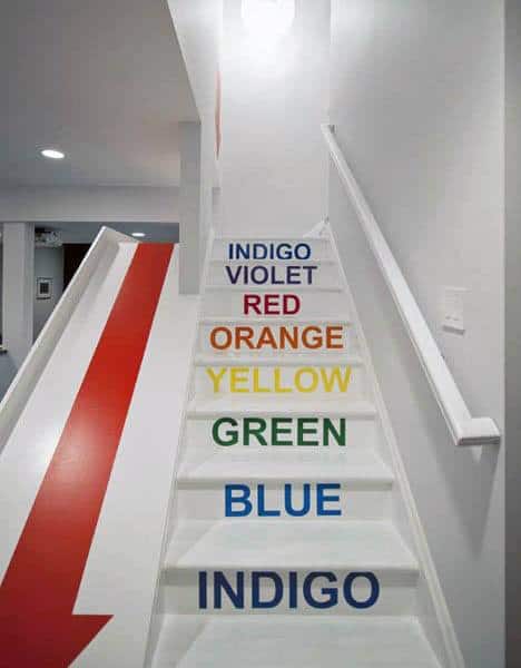 A colorful staircase transforms into a playful slide, each step labeled indigo, violet, red, orange, yellow, green