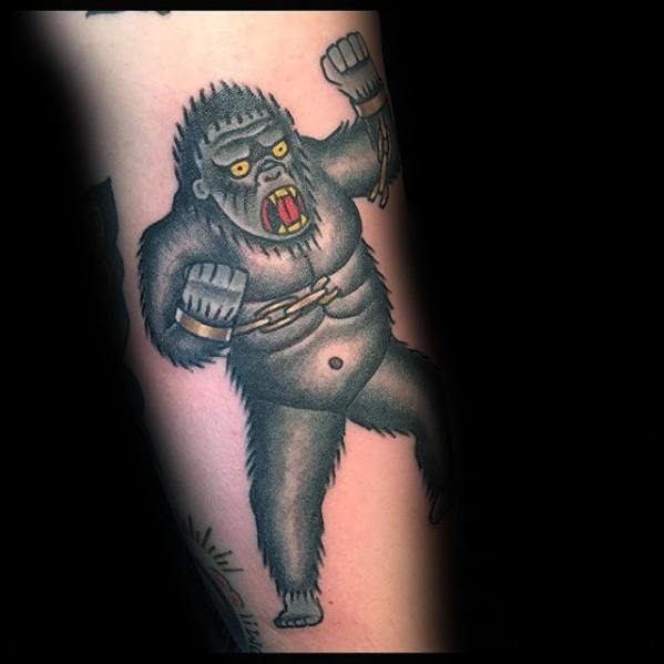 Traditional-style King Kong tattoo featuring a cartoonish Kong breaking free from chains with bold outlines and simple shading.