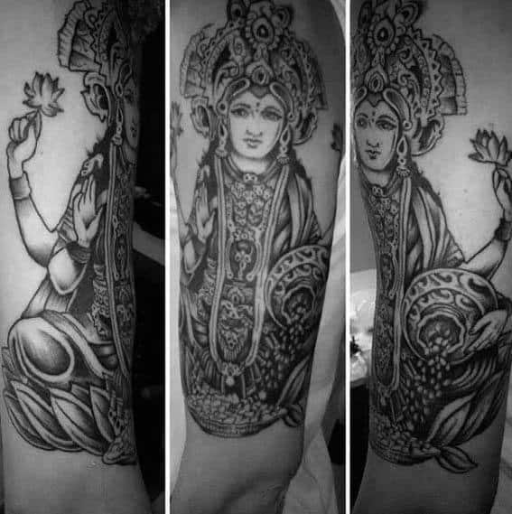 Large black and grey Krishna tattoo featuring an elaborately detailed depiction of Lord Krishna seated on a lotus, holding a lotus flower.