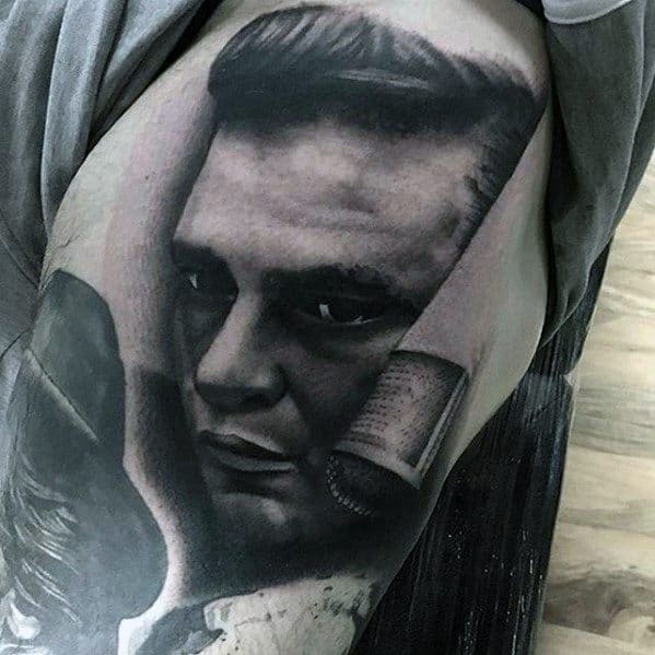 Hyper-realistic tattoo of Johnny Cash featuring a vintage microphone, capturing his intense gaze and iconic style