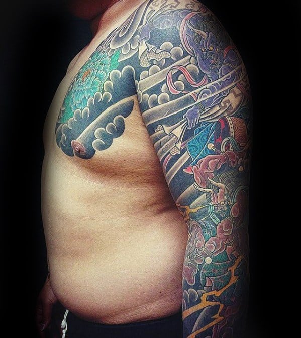 Intricate Raijin full sleeve and chest tattoo with detailed thunder god, swirling clouds, lightning, and vibrant Japanese-style elements.