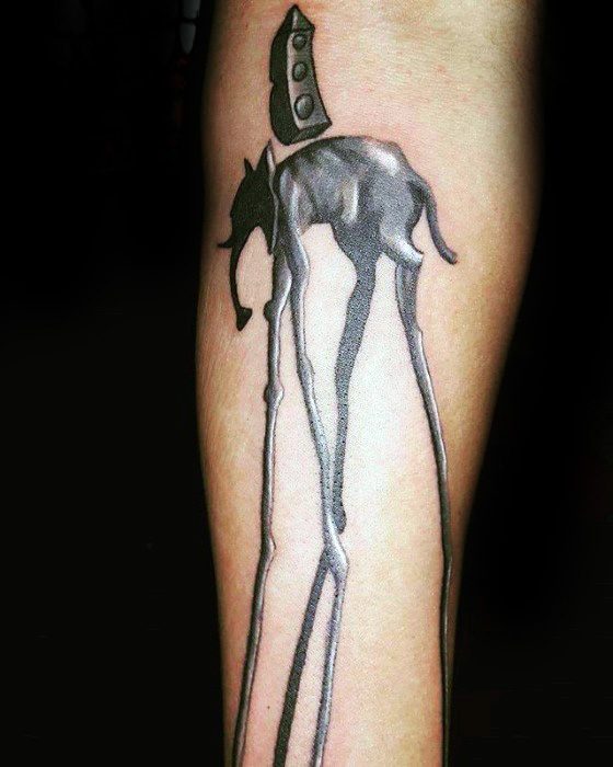 Glossy black and grey Salvador Dali-style tattoo of a surreal elephant with long, slender legs and an abstract obelisk on its back.