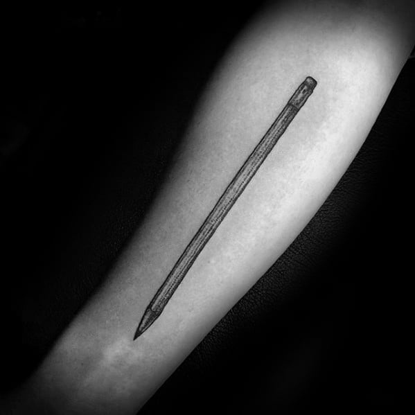 A lifelike pencil tattoo elegantly graces a person's forearm, intricately depicted in striking black and white